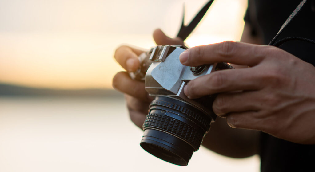 backpacker relax on the mountain with camera adn sunset